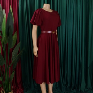 Detail of burgundy dress featuring puff sleeves and a thin waist belt with a gold buckle
