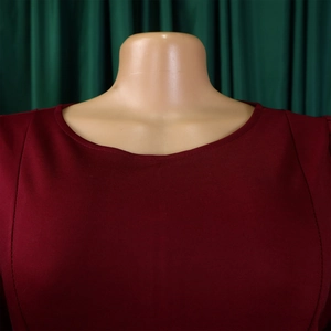 Close-up detail of the wine red crew neck and high-quality stitching on the elegant A-line dress