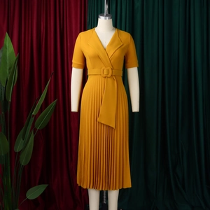 Detail view of the V-neckline and matching square buckle belt on yellow pleated dress