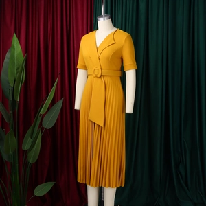 Detail of ginger pleated dress featuring a classic lapel and matching belted waist design