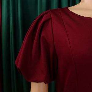 Close-up of wine red dress featuring retro puff sleeves and pleated shoulder details