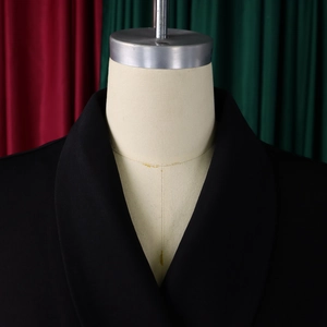 Detail van zwarte blazer met sjaalkraag en gebreide textuur op een display mannequin