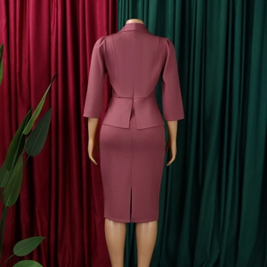 Rear view of a pink two-piece skirt suit with notched collar and back slit details