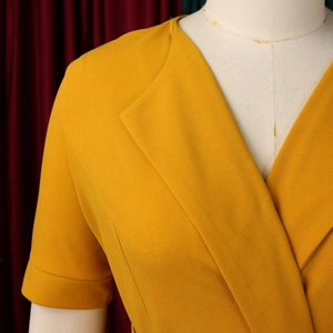 Detail of elegant bright yellow V-neck dress with pleated texture and short folded sleeves