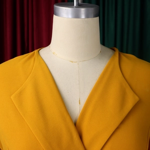 Detail of the V-neck lapel and fine textured fabric of this yellow ginger dress