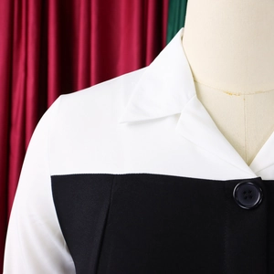 Detail of black and white patchwork dress with a lapel collar and large button ornament