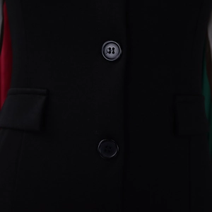 Detailed close-up of professional black blazer dress showing buttons and flap pockets