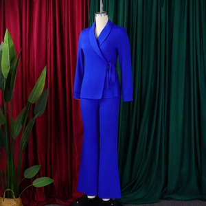 Detail van koningsblauw tweedelig pak met gestrikte blazer en wijde pijpen broek