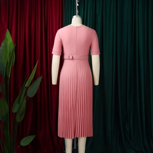 Detail view of pink short-sleeve pleated dress featuring a high waist and matching fabric belt