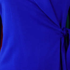 Detail van koningsblauw overslagjasje met V-hals en een elegante strik in de taille