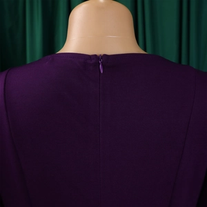 Detail of dark purple dress featuring an invisible back zipper and textured fabric