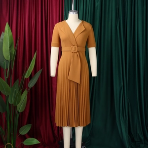 Detail of elegant V-neck pleated midi dress in caramel yellow with wide waist belt