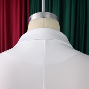 Detailopname van de stiksels op de kraag en schouder van een witte blazerset