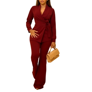 Detail van bordeauxrode overslagblazer set met tailleband en bijpassende flare broek