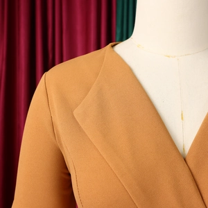 Detail of mustard yellow pleated dress fabric texture on white mannequin with V-neckline