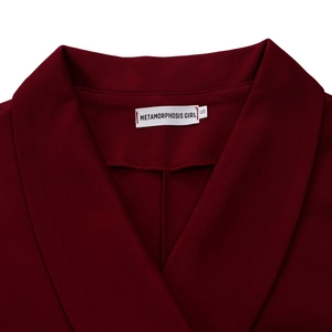 Detailopname van bordeauxrode pakboord met merklabel en fijne stoftextuur