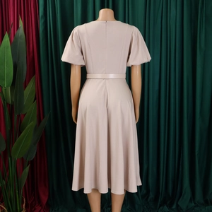 Detail of elegant apricot A-line dress with puff sleeves and slim waist belt from the back