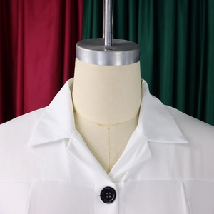 Detail of white pencil dress lapel with contrasting black four-hole button closure
