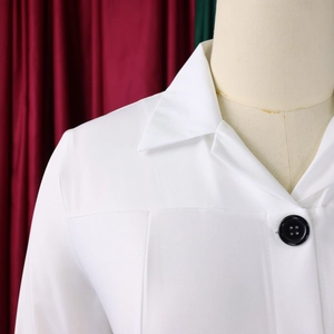 Detail of the white blazer collar with shoulder stitching and black button on a mannequin