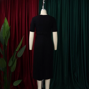 Detail of elegant black pleated midi dress featuring waist tie and accordion pleats
