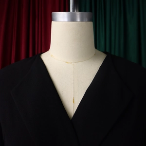 Detailed view of women's black formal suit jacket featuring a classic notched lapel design