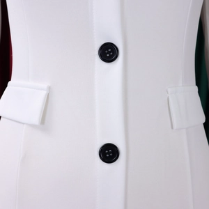 Detail of white blazer dress showing black buttons and symmetric flap pockets