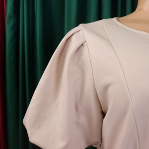Detail of puff sleeves and textured beige fabric on an elegant A-line dress
