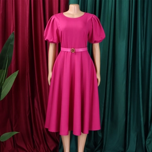 Detail of rose red dress featuring puff sleeves and a waist belt with golden metal buckle