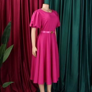 Detail of the elegant magenta puff sleeve dress featuring a round neck and buckled belt