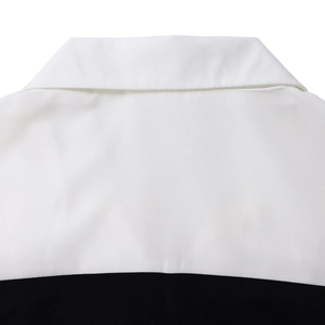 Detailed view of black and white patchwork lapel collar with professional stitching quality