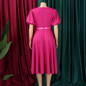 Detail view of the back of a magenta puff sleeve dress with zipper and thin waist belt