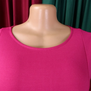 Detailed close-up of the round neckline and textured knit fabric on this magenta dress