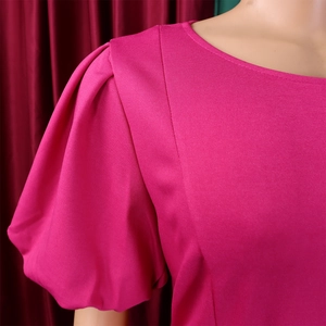 Detail of round neckline and puff sleeves on magenta dress with fine stitching texture