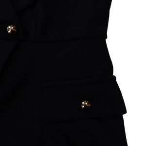 Detail of elegant black dress showing high-density fabric and metallic gold buttons