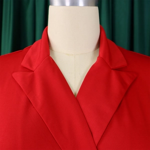 Détail du revers à encoche et du tissu texturé sur une robe rouge à double boutonnage