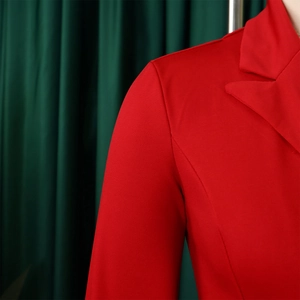 Détail de la robe rouge à double boutonnage montrant le revers net et les épaulettes