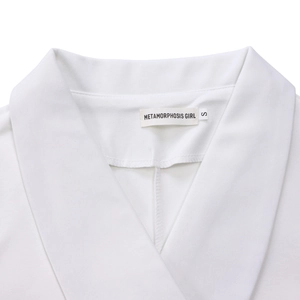 Detailopname van witte blazer revers en S-maattabel op glad geweven materiaal