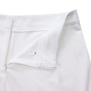 Detail van de witte geweven tailleband met onzichtbare rits en een ingenaaid maatlabel
