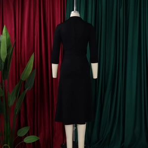 Achteraanzicht van een klassieke zwarte midi-jurk met getailleerde taille en riem