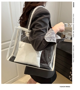 Detail of transparent PVC tote bag featuring a white leather inner pouch and rope handles