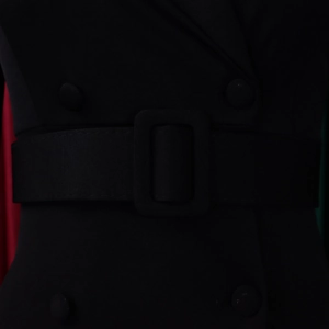 Detail van de tailleriem en beklede gesp op een zwarte double-breasted jurk
