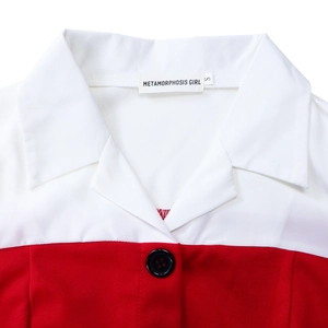 Detail of red and white patchwork blazer dress with black button and brand size tag