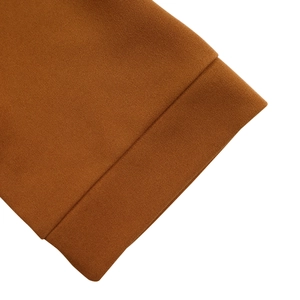 Close-up of caramel pleated knit fabric texture and high-quality hem detailing