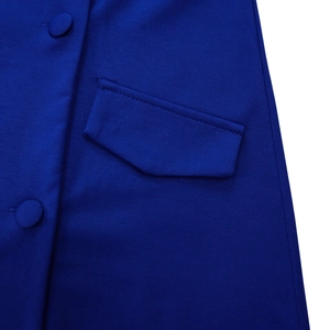 Detailopname van de donkerblauwe jurkstof met beklede knopen en een zakontwerp detail
