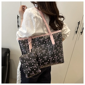 Close-up of bow print tote bag set with matching small pouch and pink shoulder straps