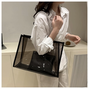 Close-up of transparent smoky grey PVC tote with thick woven rope handles and inner pouch