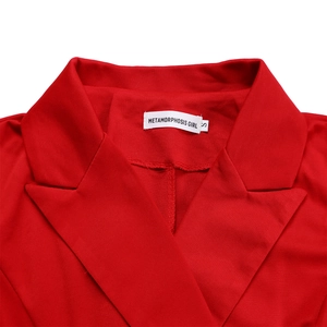 Gros plan du col de la veste rouge avec l'étiquette de marque blanche et la taille S