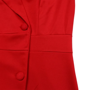 Gros plan d'une robe tailleur rouge avec boutons recouverts et revers en pointe
