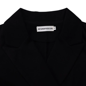 Detail van de halslijn van de double-breasted jurk met METAMORPHOSIS GIRL merklabel