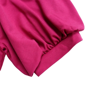 Detailed close-up of ribbed cuffs and elastic texture on rose red elegant dress